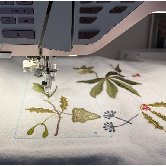 Botanical machine embroidery: hellebores, green leaves, red berries on light felt  