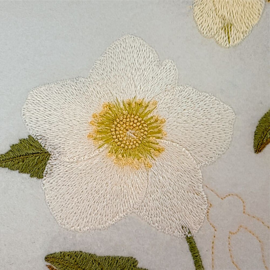 Botanical machine embroidery: hellebores, green leaves, red berries on light felt  
